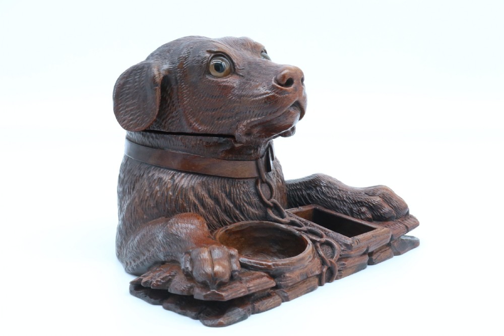 A 19th-century carved wooden tobacco box formed as a dog head with glass eyes and a hinged lid, set on a base with carved trays. View III