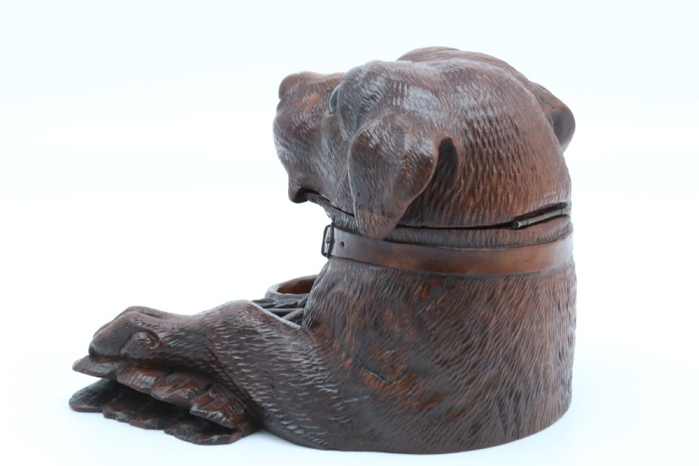 A 19th-century carved wooden tobacco box formed as a dog head with glass eyes and a hinged lid, set on a base with carved trays. View VII