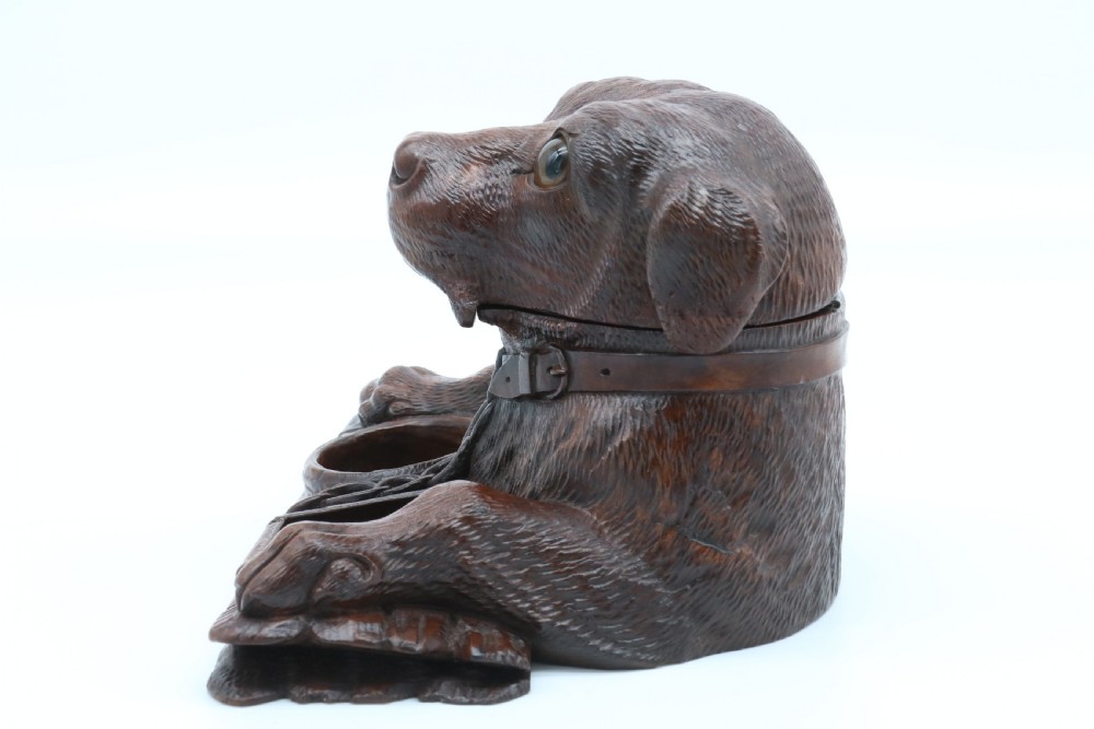 A 19th-century carved wooden tobacco box formed as a dog head with glass eyes and a hinged lid, set on a base with carved trays. View VIII