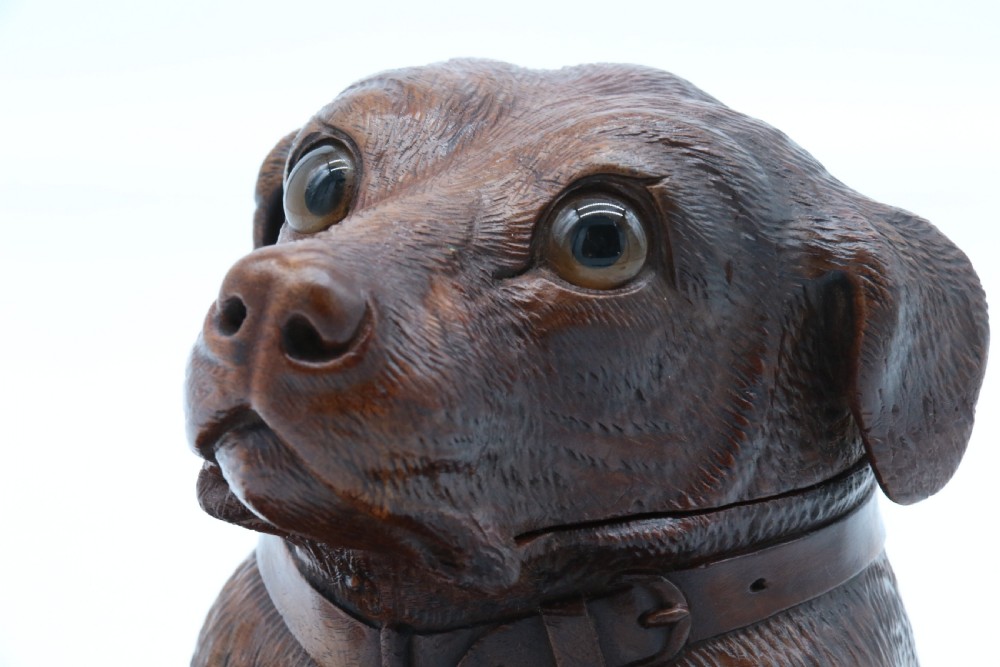 A 19th-century carved wooden tobacco box formed as a dog head with glass eyes and a hinged lid, set on a base with carved trays. View XIII