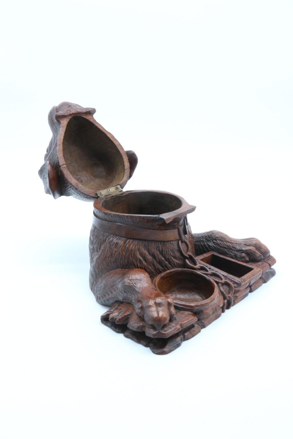 A 19th-century carved wooden tobacco box formed as a dog head with glass eyes and a hinged lid, set on a base with carved trays. View XVI
