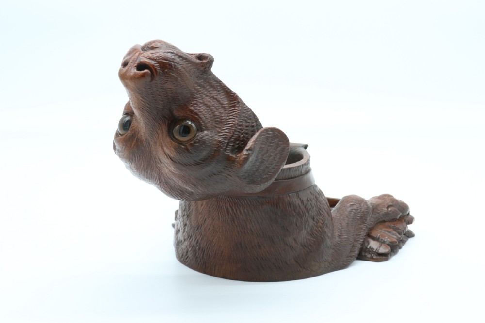 A 19th-century carved wooden tobacco box formed as a dog head with glass eyes and a hinged lid, set on a base with carved trays. View XVIII