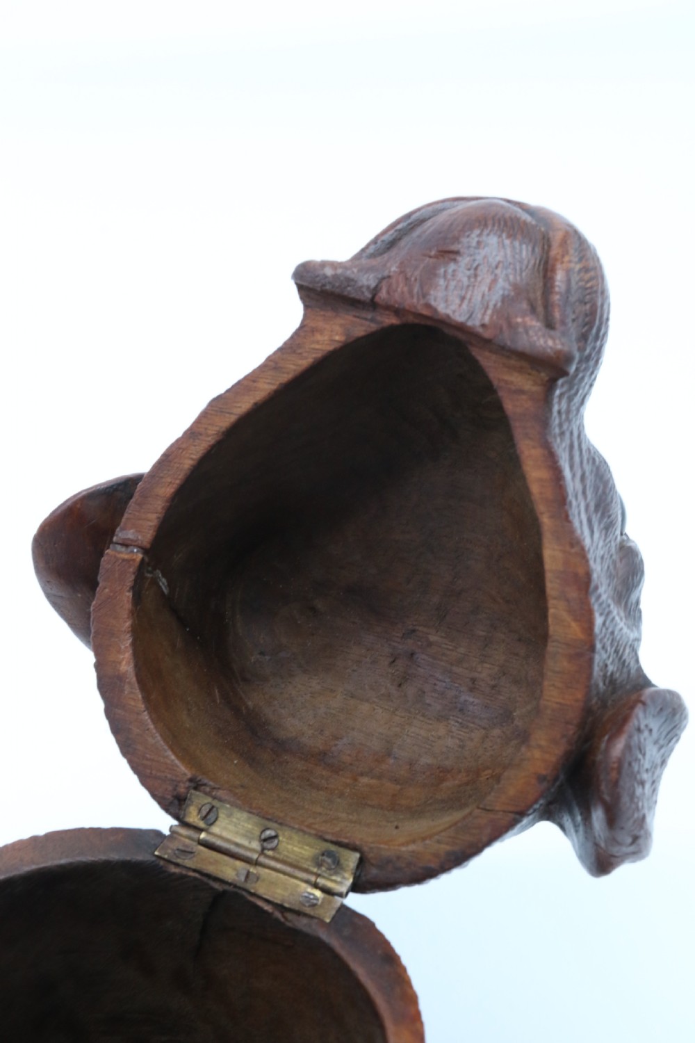 A 19th-century carved wooden tobacco box formed as a dog head with glass eyes and a hinged lid, set on a base with carved trays. View XX