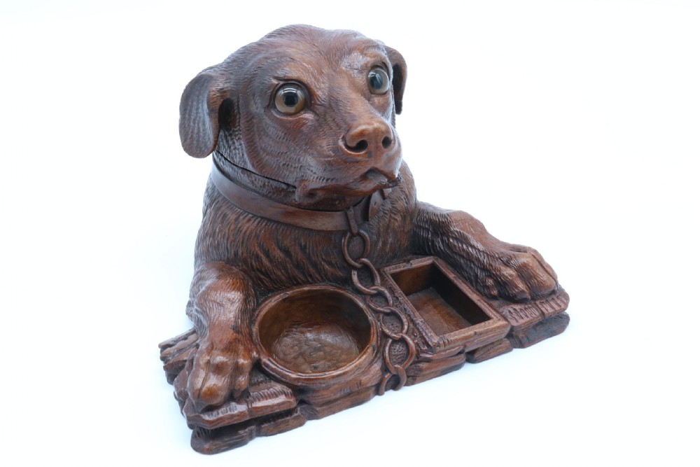 A 19th-century carved wooden tobacco box formed as a dog head with glass eyes and a hinged lid, set on a base with carved trays. View XXIII