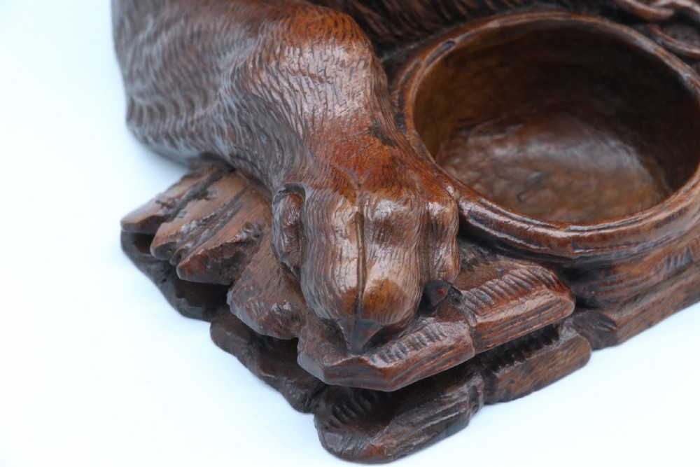 A 19th-century carved wooden tobacco box formed as a dog head with glass eyes and a hinged lid, set on a base with carved trays. View XXVI
