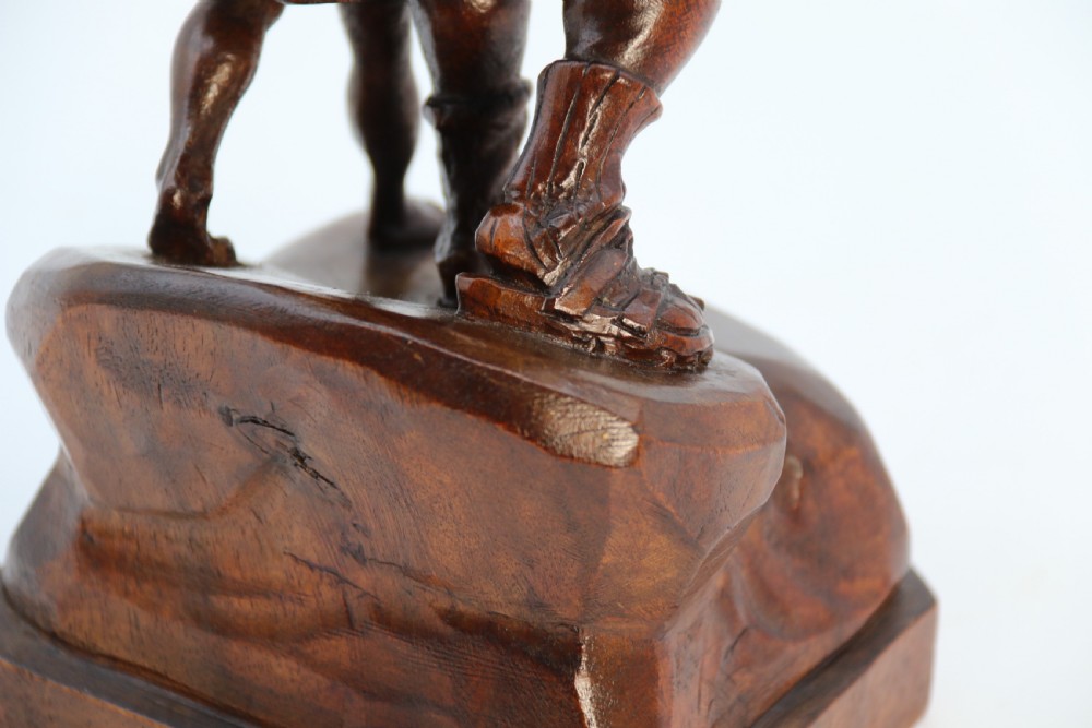 A hand-carved dark walnut wood sculpture depicting William Tell holding a crossbow alongside his son on a base carved with the date 1307. View XVII