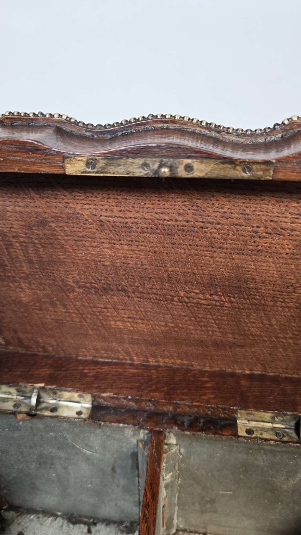A dark carved oak tea caddy featuring copper relief caryatids, a central lock plate, and a decorative figural lid crest. View XXII