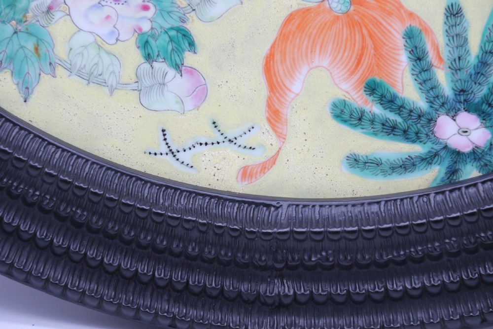 A circular framed Chinese porcelain plaque featuring vibrant hand-painted goldfish and lotus flowers on a yellow background enclosed in a carved dark frame. View XV