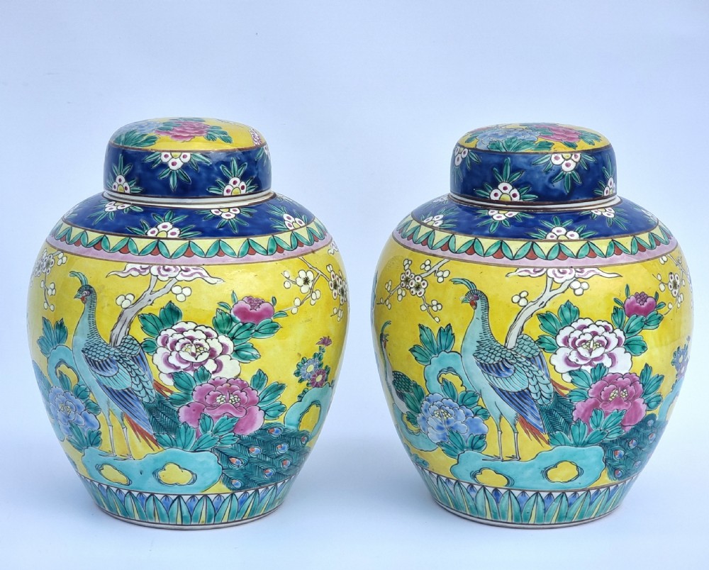 A matching pair of yellow porcelain ginger jars featuring hand-painted blue and turquoise phoenixes among peonies and floral branches, topped with deep blue decorated lids. View II