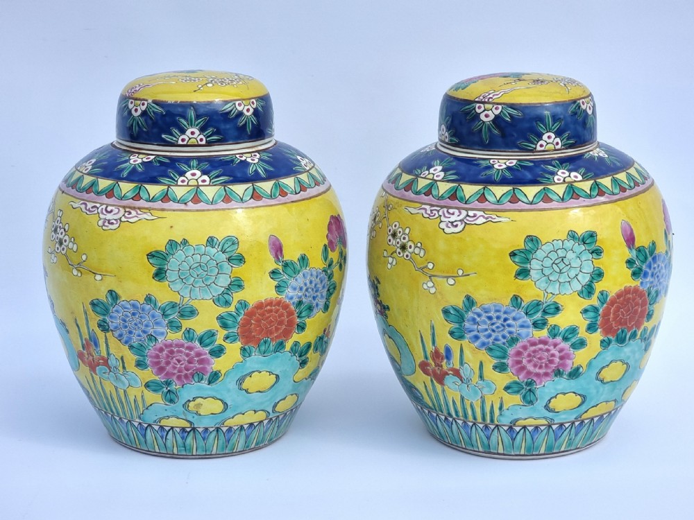 A matching pair of yellow porcelain ginger jars featuring hand-painted blue and turquoise phoenixes among peonies and floral branches, topped with deep blue decorated lids. View V