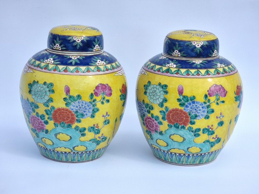 A matching pair of yellow porcelain ginger jars featuring hand-painted blue and turquoise phoenixes among peonies and floral branches, topped with deep blue decorated lids. View VI