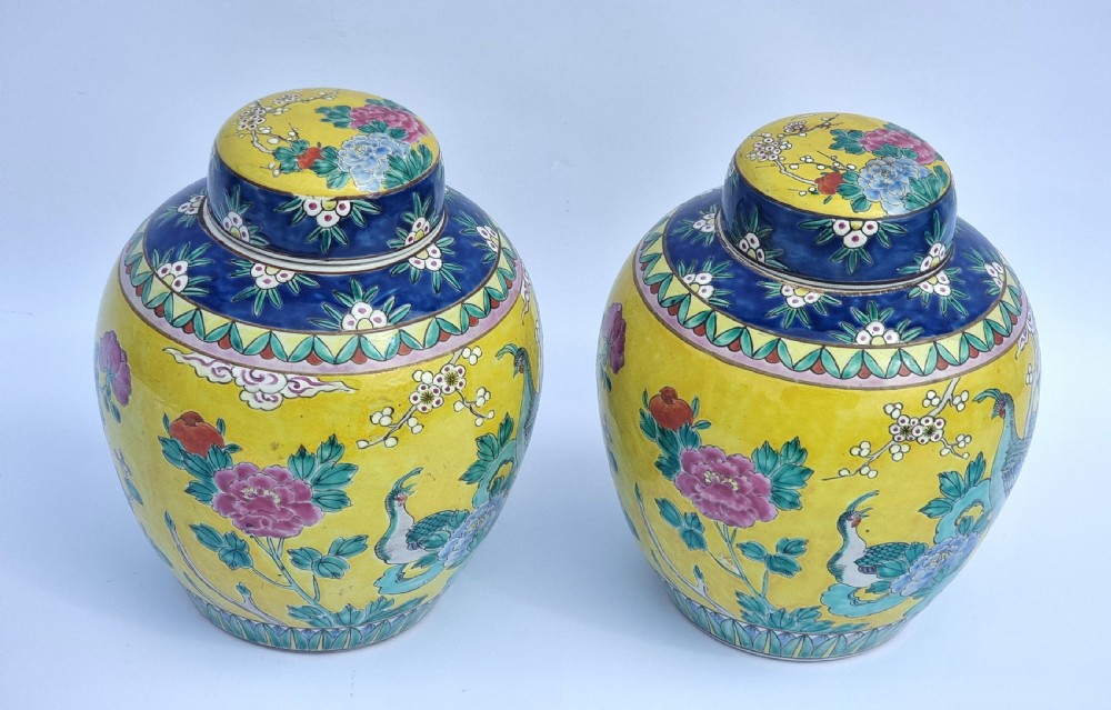 A matching pair of yellow porcelain ginger jars featuring hand-painted blue and turquoise phoenixes among peonies and floral branches, topped with deep blue decorated lids. View VIII