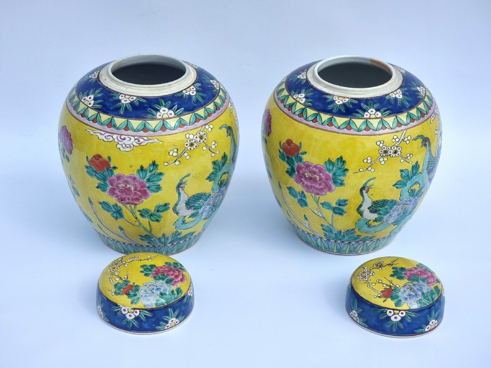 A matching pair of yellow porcelain ginger jars featuring hand-painted blue and turquoise phoenixes among peonies and floral branches, topped with deep blue decorated lids. View IX