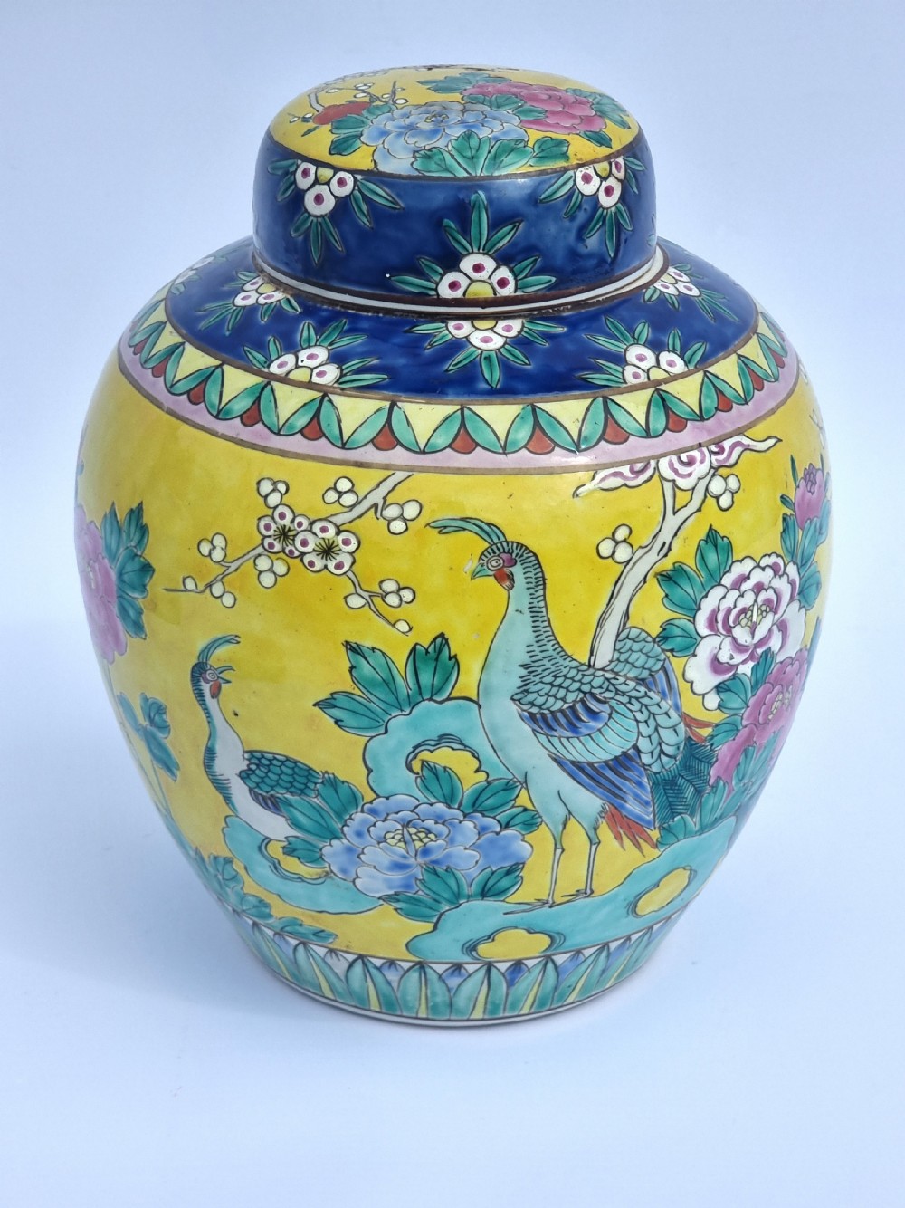 A matching pair of yellow porcelain ginger jars featuring hand-painted blue and turquoise phoenixes among peonies and floral branches, topped with deep blue decorated lids. View XV