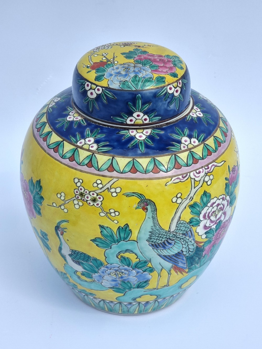 A matching pair of yellow porcelain ginger jars featuring hand-painted blue and turquoise phoenixes among peonies and floral branches, topped with deep blue decorated lids. View XVI