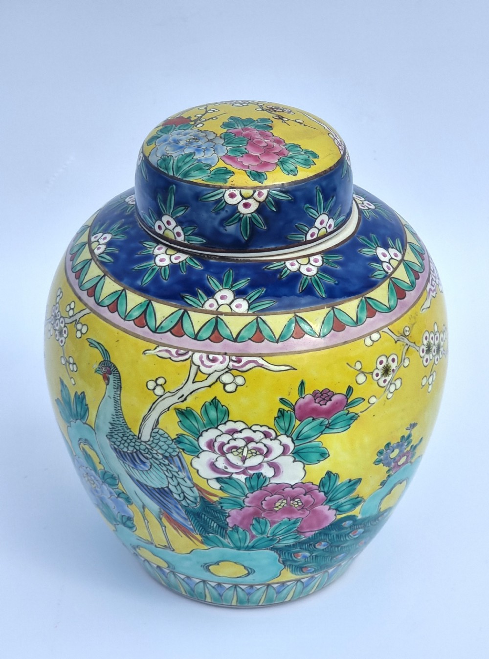 A matching pair of yellow porcelain ginger jars featuring hand-painted blue and turquoise phoenixes among peonies and floral branches, topped with deep blue decorated lids. View XVII