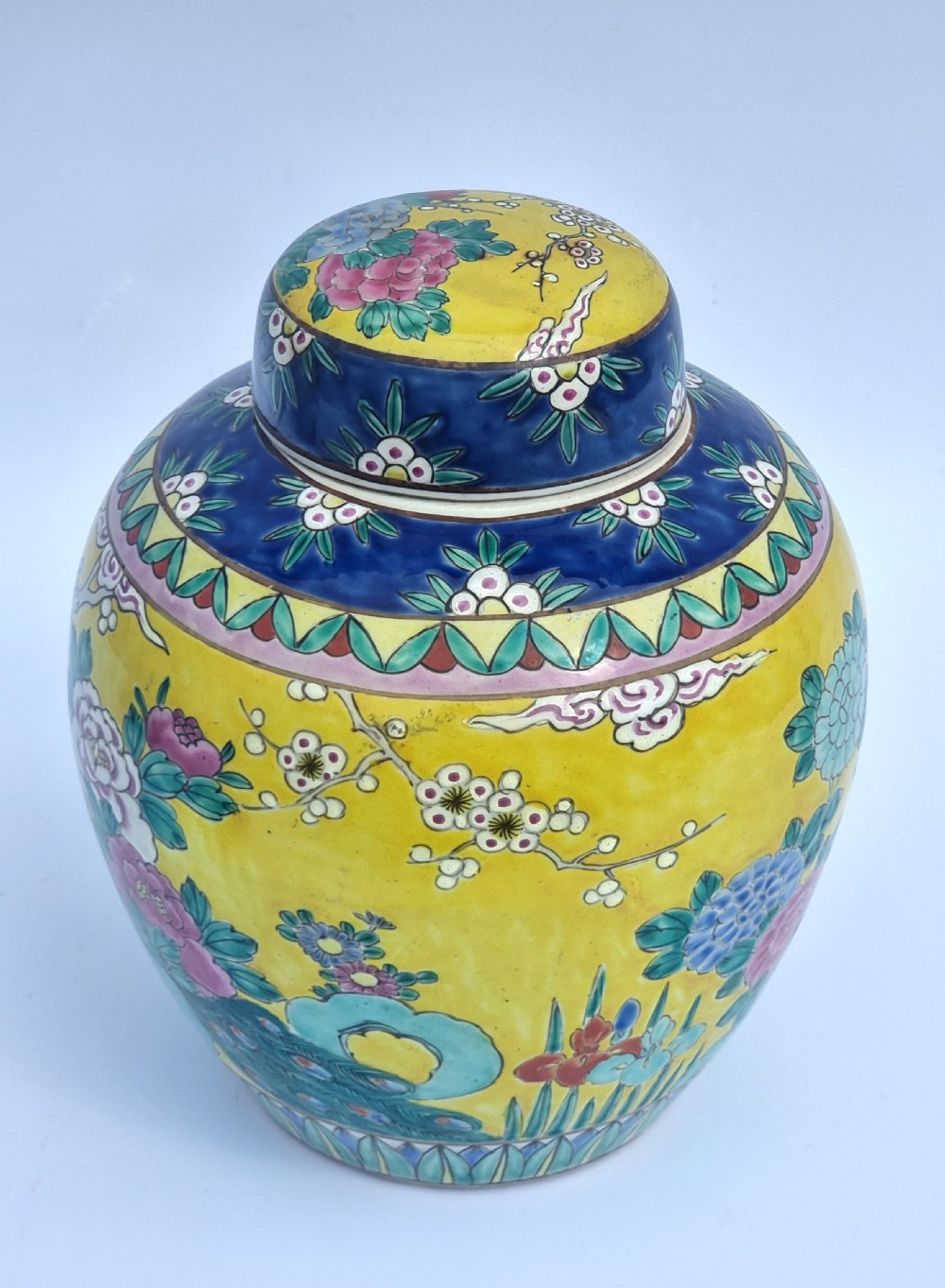 A matching pair of yellow porcelain ginger jars featuring hand-painted blue and turquoise phoenixes among peonies and floral branches, topped with deep blue decorated lids. View XVIII