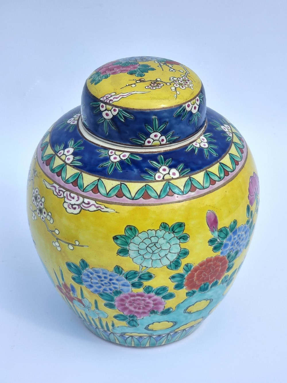 A matching pair of yellow porcelain ginger jars featuring hand-painted blue and turquoise phoenixes among peonies and floral branches, topped with deep blue decorated lids. View XIX