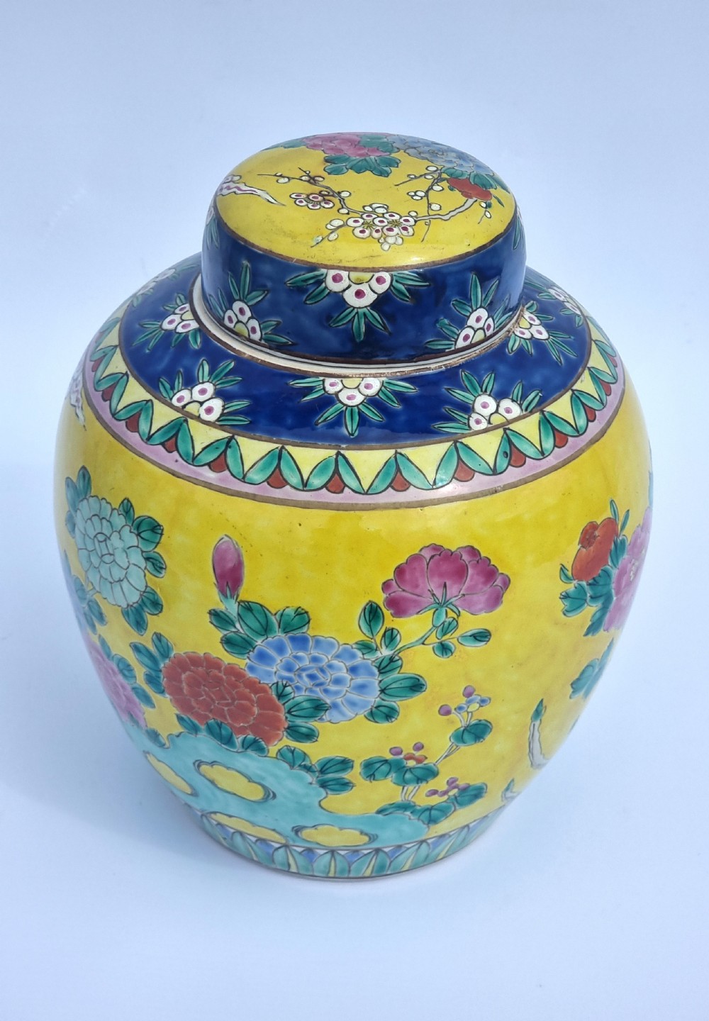 A matching pair of yellow porcelain ginger jars featuring hand-painted blue and turquoise phoenixes among peonies and floral branches, topped with deep blue decorated lids. View XX