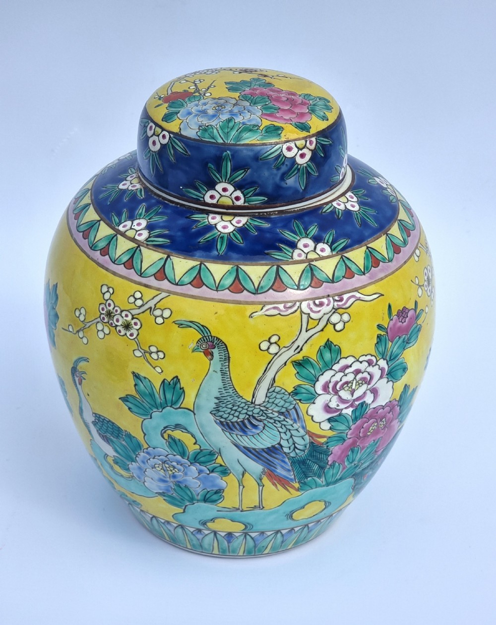 A matching pair of yellow porcelain ginger jars featuring hand-painted blue and turquoise phoenixes among peonies and floral branches, topped with deep blue decorated lids. View XXII