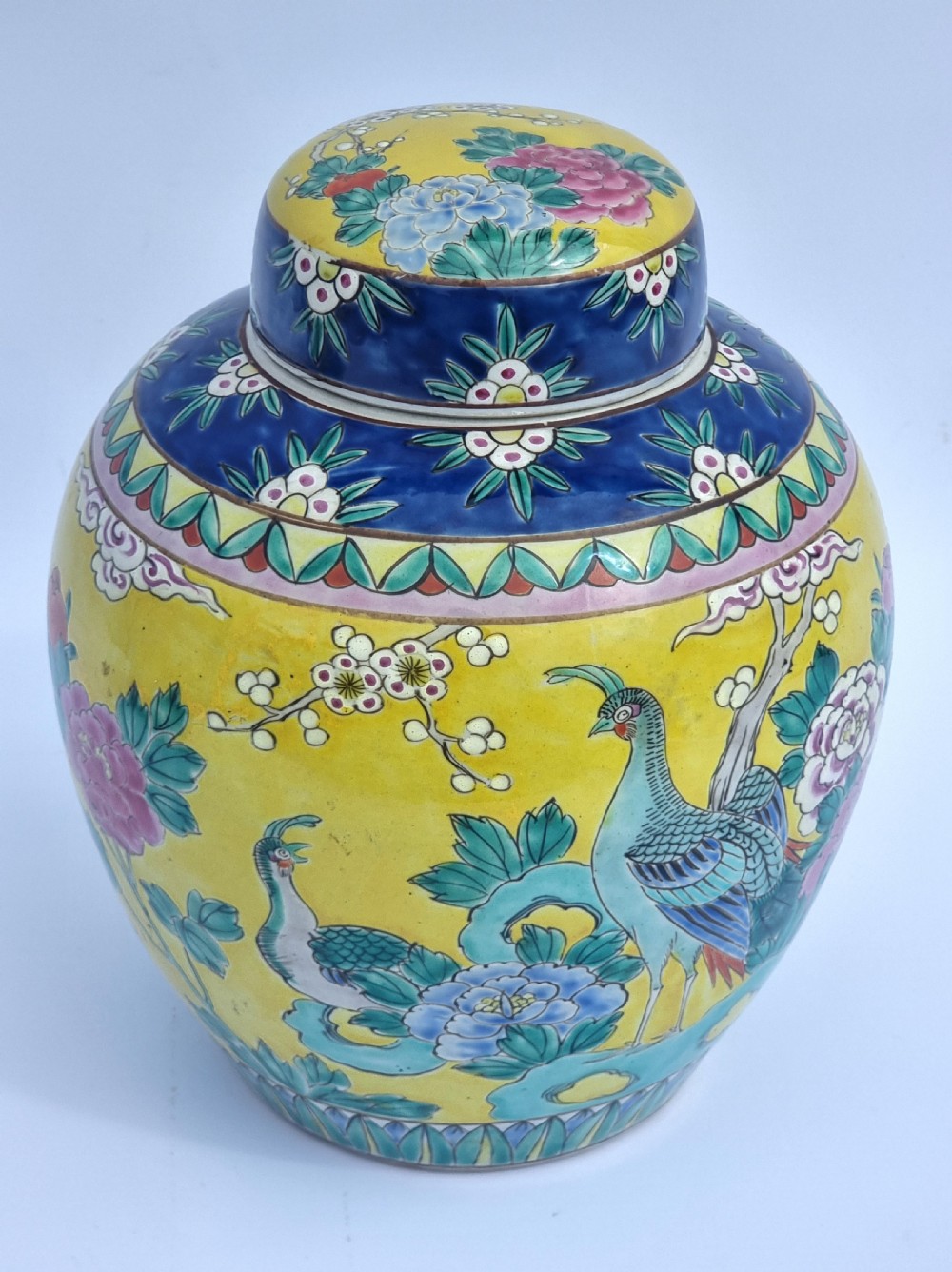 A matching pair of yellow porcelain ginger jars featuring hand-painted blue and turquoise phoenixes among peonies and floral branches, topped with deep blue decorated lids. View XXIII