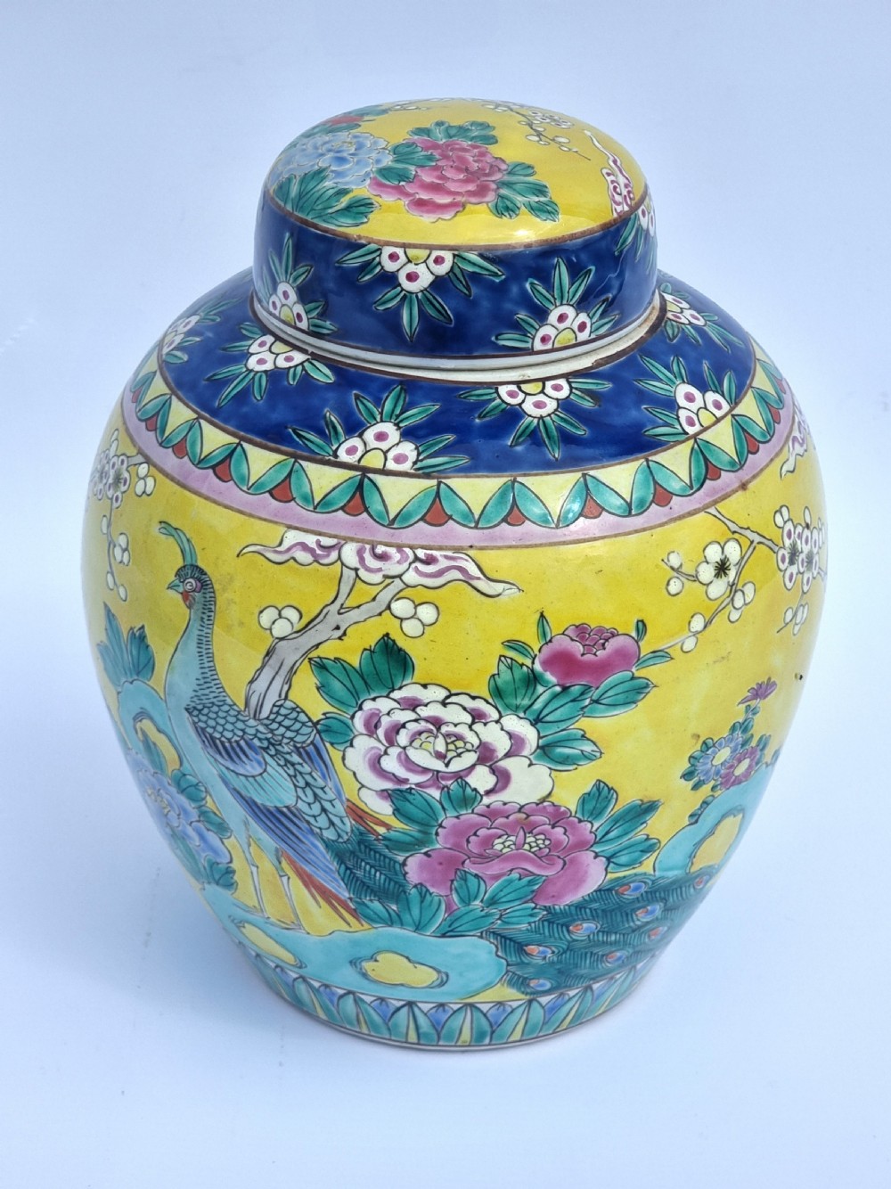 A matching pair of yellow porcelain ginger jars featuring hand-painted blue and turquoise phoenixes among peonies and floral branches, topped with deep blue decorated lids. View XXIV