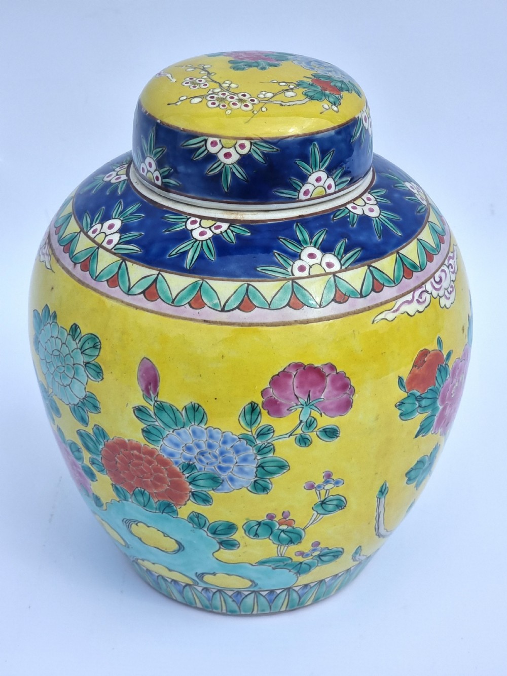 A matching pair of yellow porcelain ginger jars featuring hand-painted blue and turquoise phoenixes among peonies and floral branches, topped with deep blue decorated lids. View XXVII