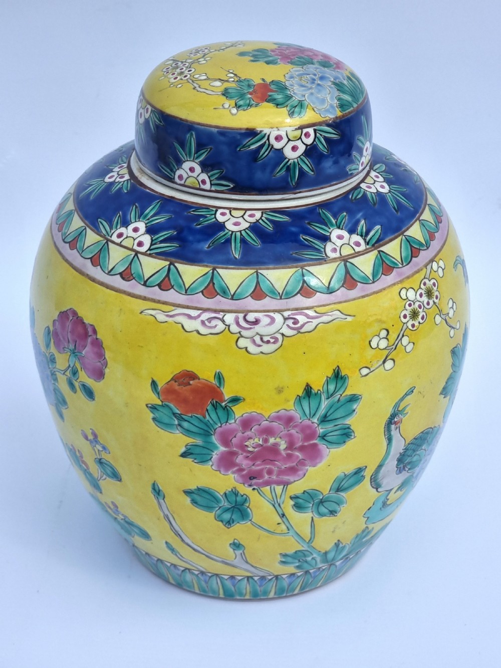 A matching pair of yellow porcelain ginger jars featuring hand-painted blue and turquoise phoenixes among peonies and floral branches, topped with deep blue decorated lids. View XXVIII