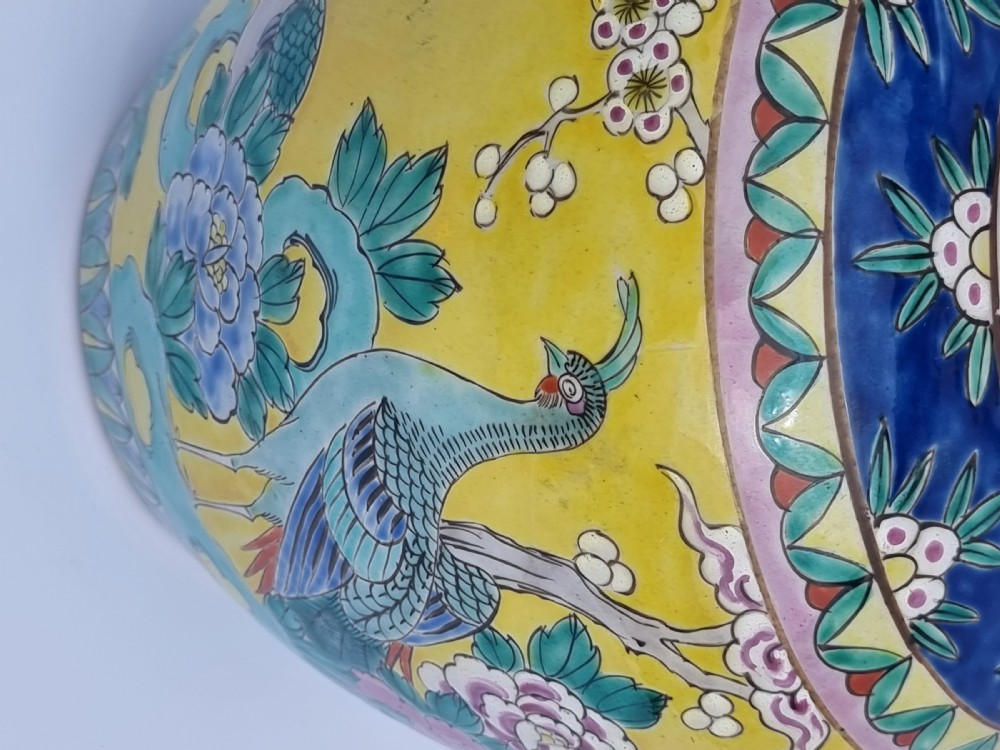 A matching pair of yellow porcelain ginger jars featuring hand-painted blue and turquoise phoenixes among peonies and floral branches, topped with deep blue decorated lids. View XXX