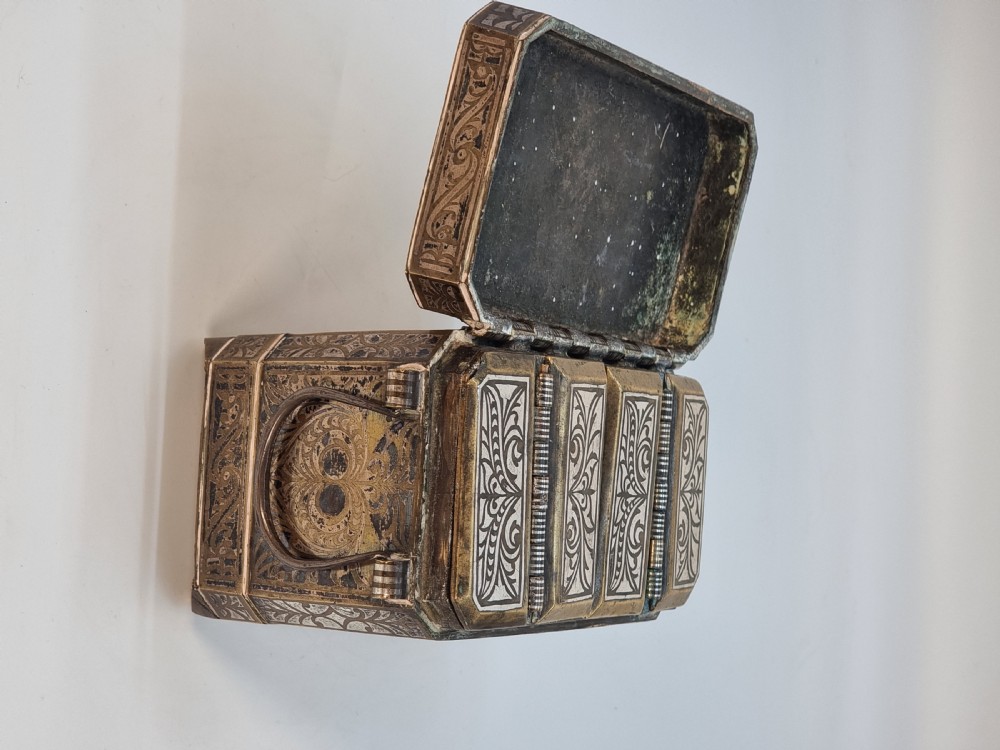 A rectangular dark bronze box featuring elaborate silver scrollwork inlay, side carrying handles, and small bracket feet. View XIV