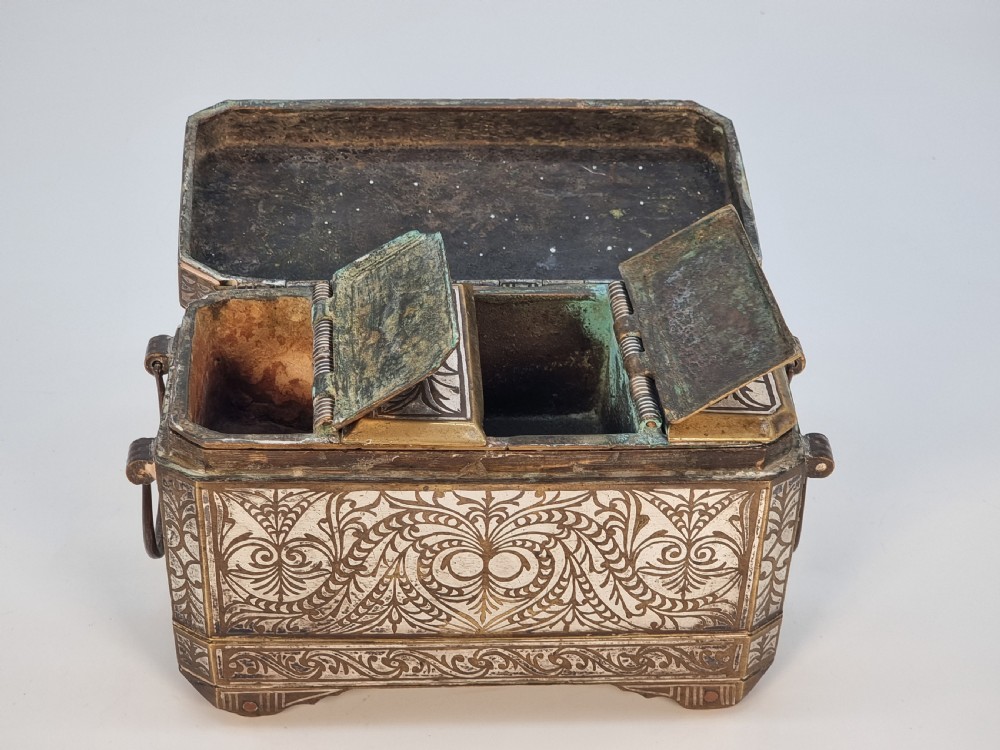 A rectangular dark bronze box featuring elaborate silver scrollwork inlay, side carrying handles, and small bracket feet. View XX