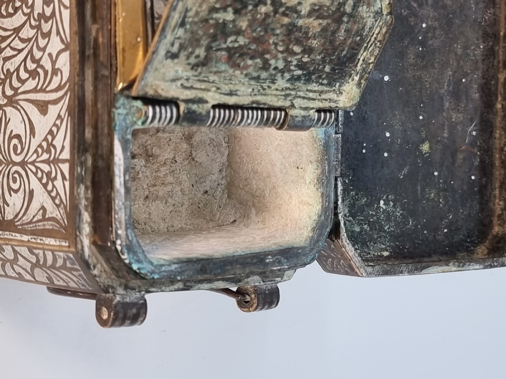 A rectangular dark bronze box featuring elaborate silver scrollwork inlay, side carrying handles, and small bracket feet. View XXII