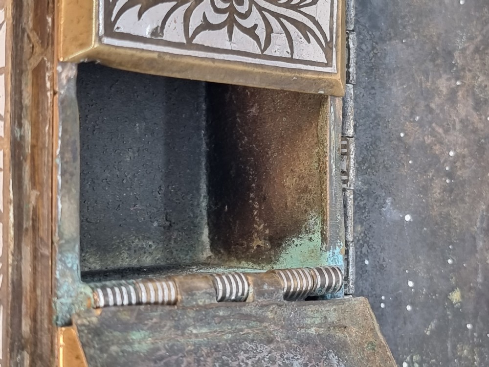 A rectangular dark bronze box featuring elaborate silver scrollwork inlay, side carrying handles, and small bracket feet. View XXIII