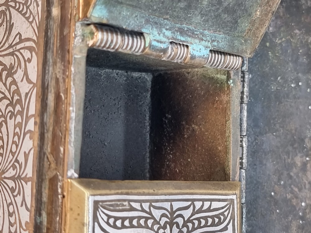 A rectangular dark bronze box featuring elaborate silver scrollwork inlay, side carrying handles, and small bracket feet. View XXIV