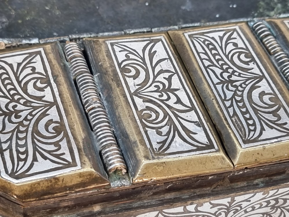 A rectangular dark bronze box featuring elaborate silver scrollwork inlay, side carrying handles, and small bracket feet. View XXVI