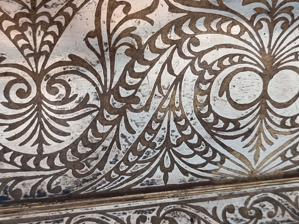 A rectangular dark bronze box featuring elaborate silver scrollwork inlay, side carrying handles, and small bracket feet. View XXVIII