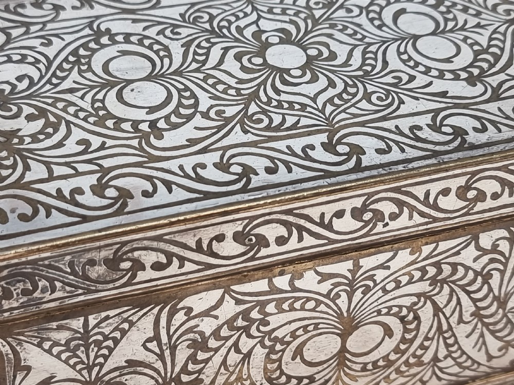 A rectangular dark bronze box featuring elaborate silver scrollwork inlay, side carrying handles, and small bracket feet. View XXIX