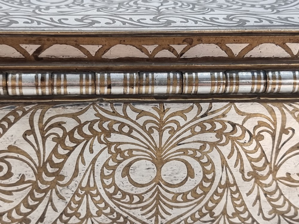 A rectangular dark bronze box featuring elaborate silver scrollwork inlay, side carrying handles, and small bracket feet. View XXX