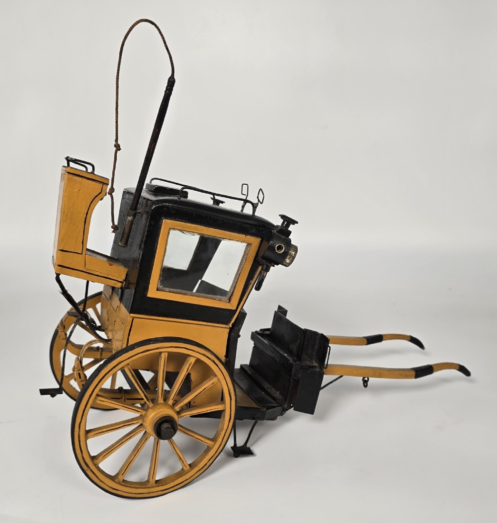 A detailed yellow and black wooden scale model of a two-wheeled 19th-century Hansom cab carriage. View XIII