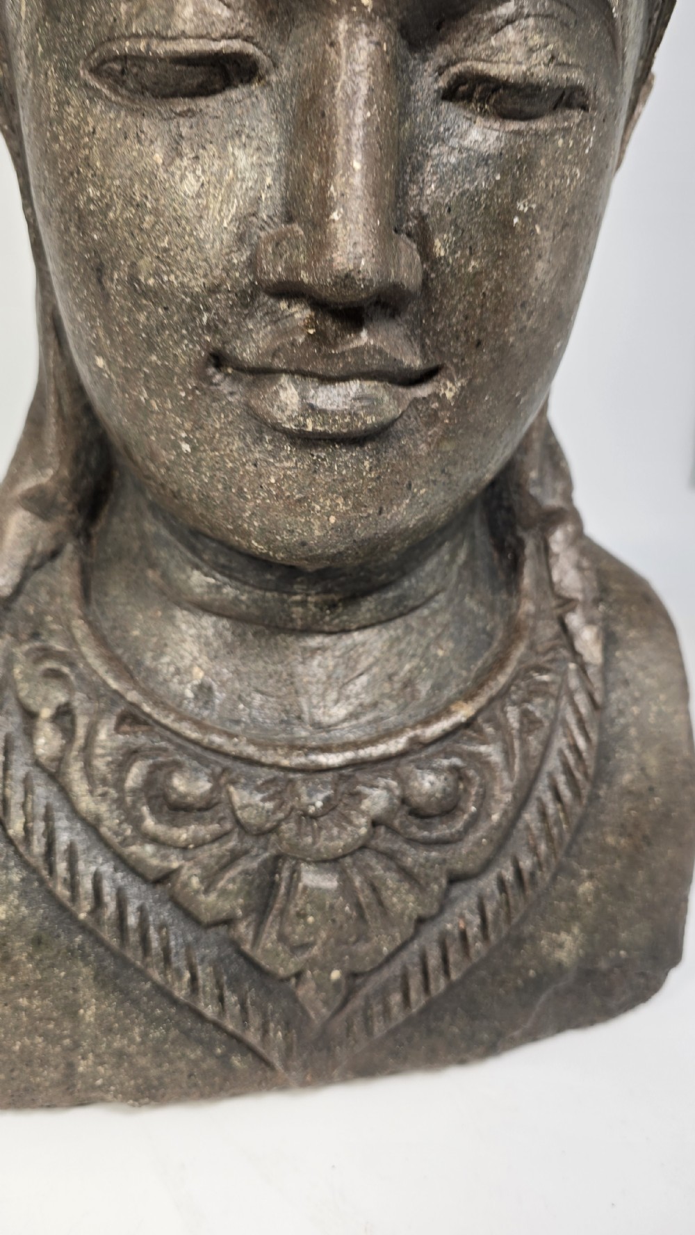 Carved dark grey stone bust of a figure supporting a floral motif planter on top of its head. View XIII