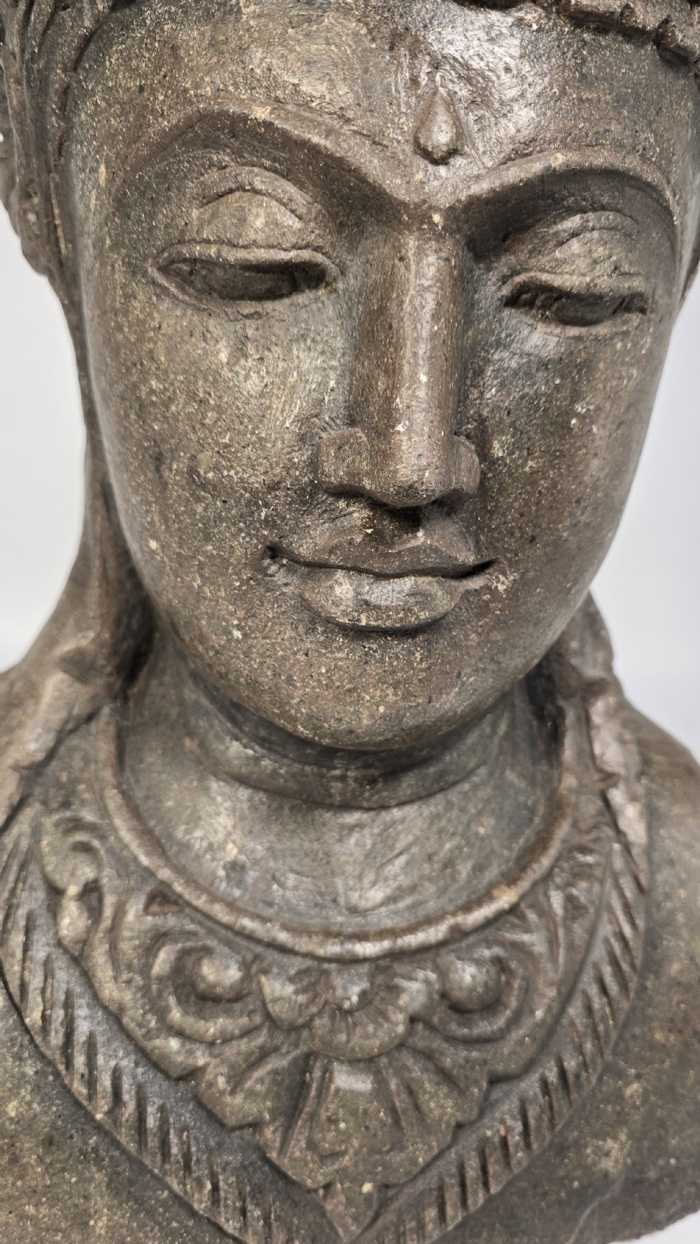 Carved dark grey stone bust of a figure supporting a floral motif planter on top of its head. View XIV