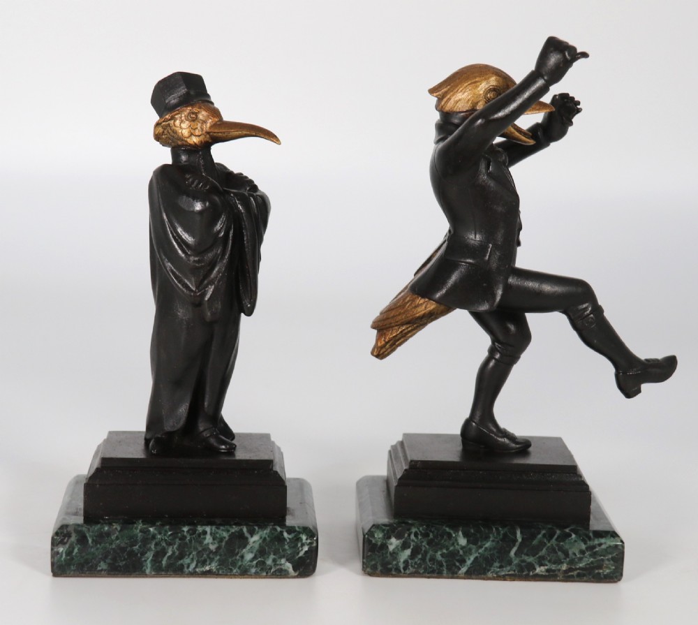 A pair of patinated and parcel-gilt bronze figures depicting anthropomorphic birds in nineteenth-century attire mounted on green marble bases. View IX