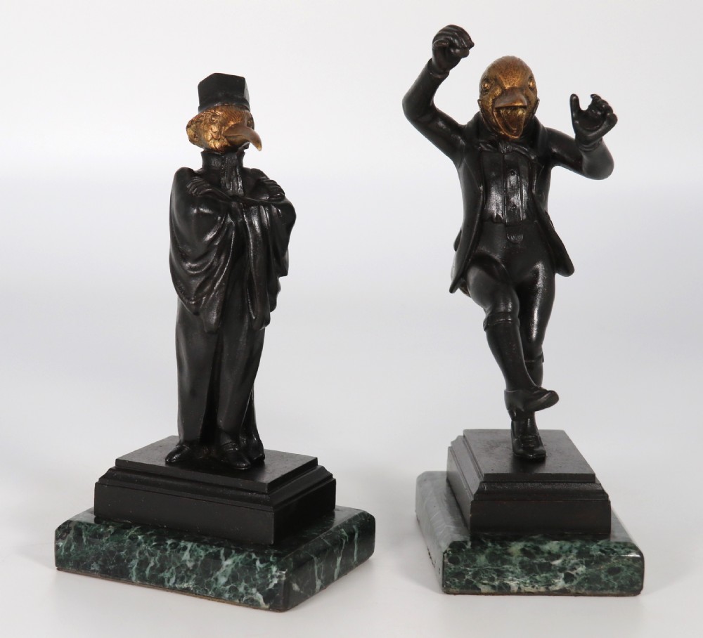A pair of patinated and parcel-gilt bronze figures depicting anthropomorphic birds in nineteenth-century attire mounted on green marble bases. View XIII