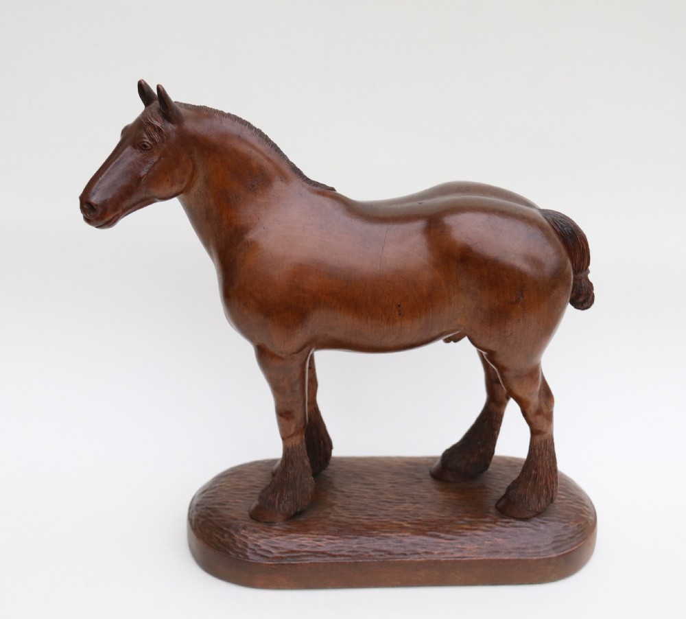 A hand-carved wooden sculpture depicting a Belgian draught horse stallion standing on an integral oval wood base. View III