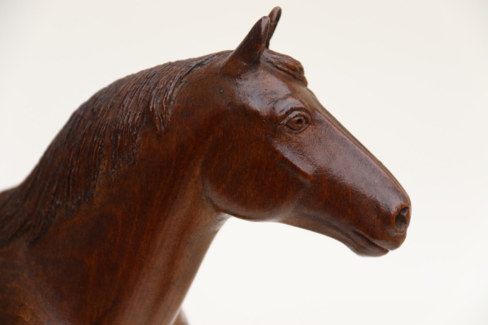 A hand-carved wooden sculpture depicting a Belgian draught horse stallion standing on an integral oval wood base. View X