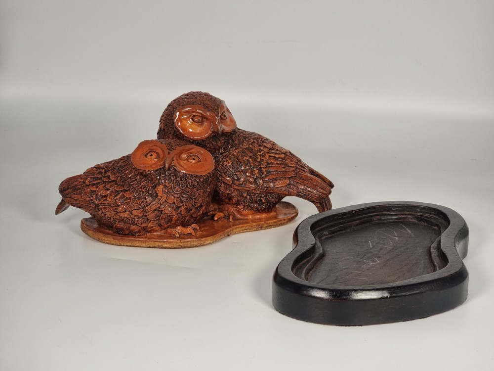 A hand-sculpted brown glazed pottery figurine of two owls perched together on a black ebonised wooden base. View XII