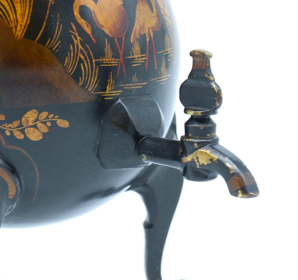 A black painted 19th-century Dutch toleware coffee urn featuring gold chinoiserie decoration, three legs, and a brass tap. View XVIII