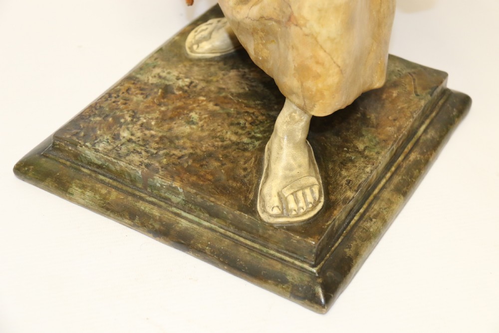 A 19th-century Goldscheider terracotta sculpture depicting a classical Roman male figure draped in robes, holding a vessel in one hand and a harvested bird in the other. View V