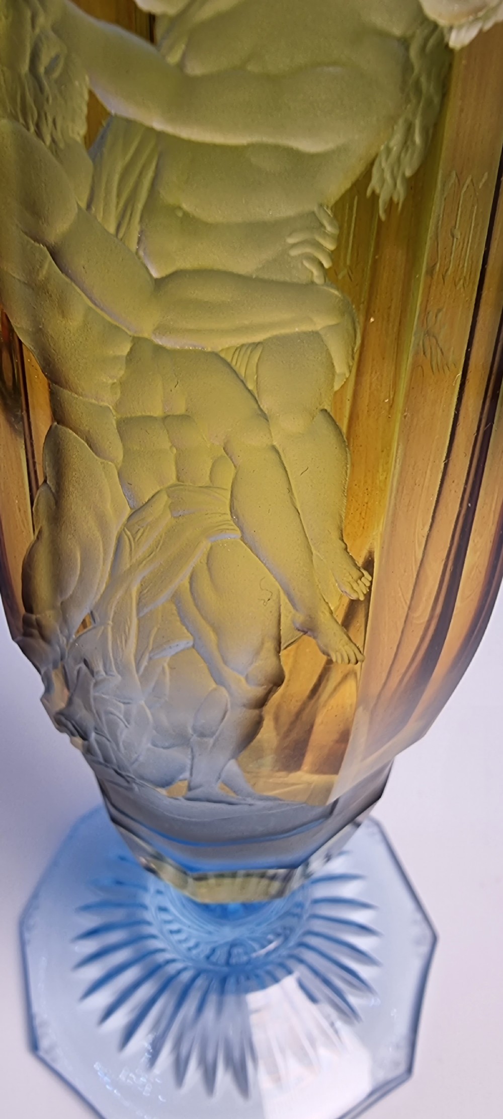 An antique Victorian amber glass goblet with wheel-engraved classical figures, supported by a light blue stem and hexagonal cut base. View IX