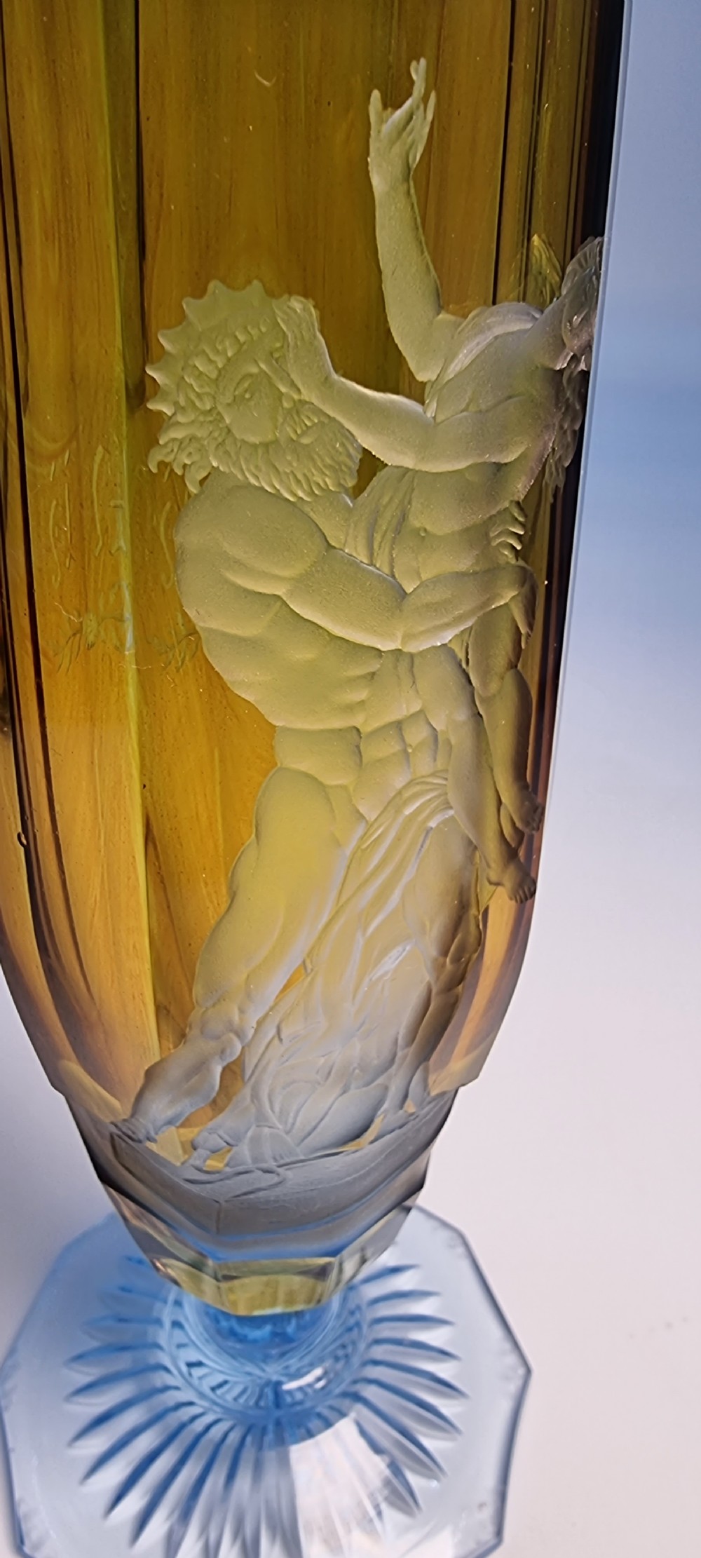 An antique Victorian amber glass goblet with wheel-engraved classical figures, supported by a light blue stem and hexagonal cut base. View XII